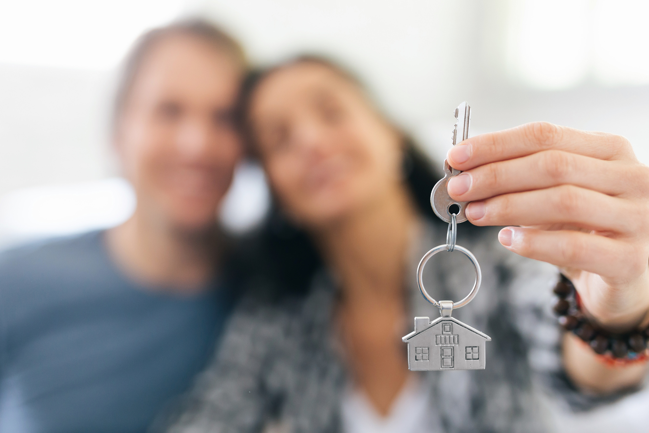 Couple cheerful home owners holding a key